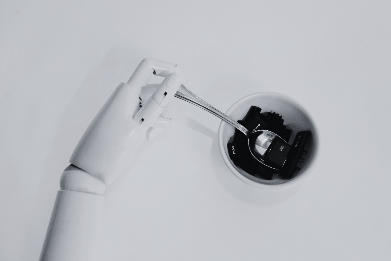 Grafika przedstawiająca robota mieszającego łyżką w kubku